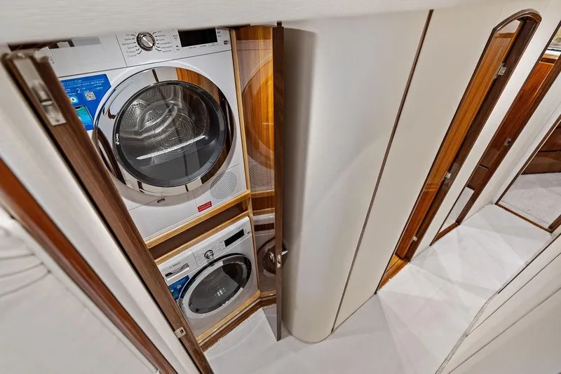 Slide: The Image of Laundry area inside 2022 Viking 48 Convertible yacht with stacked washer and dryer. - 51