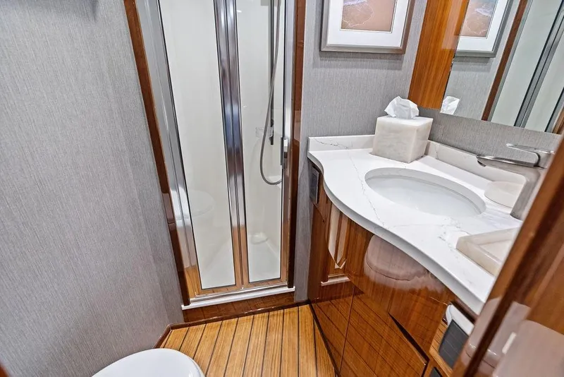 Slide: The Image of Luxurious bathroom in 2022 Viking 48 Convertible yacht with modern fixtures and wood accents. - 58