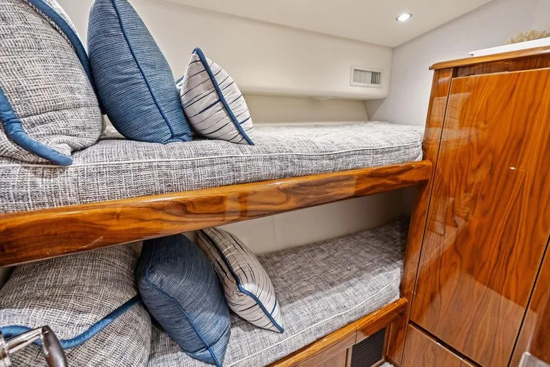 Slide: The Image of 2022 Viking 48 Convertible yacht interior with cozy bunk beds and plush pillows. - 61