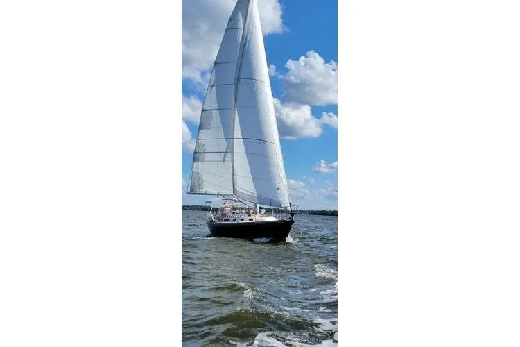 Slide: The Image of Sailing yacht Sabre 38 from 1993 on open water under a blue sky. - 1