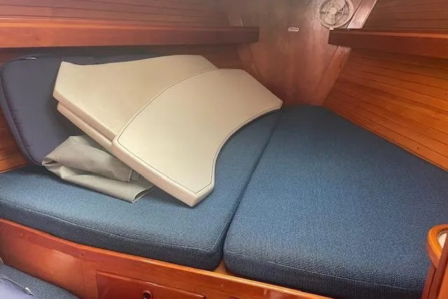 Slide: The Image of Interior cabin of 1993 Sabre 38 sailboat with blue cushions and wooden paneling. - 10