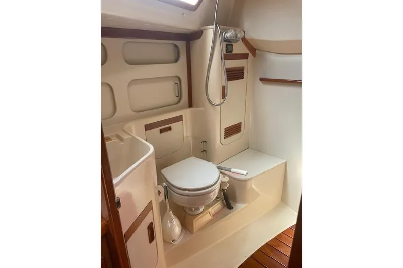 Slide: The Image of 1993 Sabre 38 yacht bathroom with toilet, shower, and wooden accents. - 12
