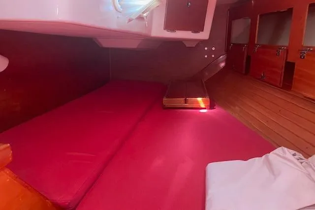 Slide: The Image of 1993 Sabre 38 yacht interior with red cushions and wooden cabinetry. - 13