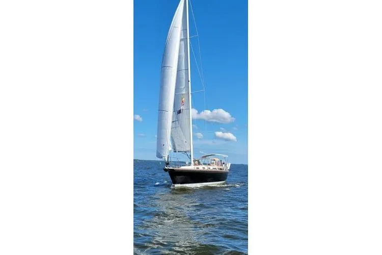 Slide: The Image of Sailing yacht Sabre 38 from 1993 on open water under clear blue sky. - 2