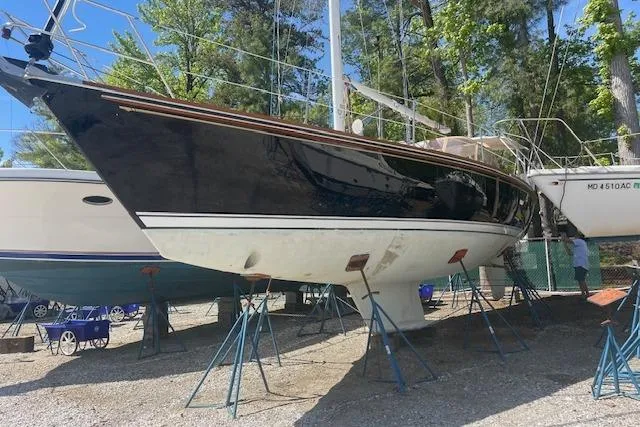 Slide: The Image of 1993 Sabre 38 sailboat on stands in a boatyard, surrounded by trees. - 23
