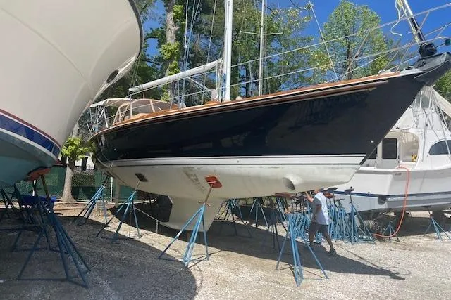 Slide: The Image of 1993 Sabre 38 sailboat on stands in a boatyard, surrounded by trees. - 24