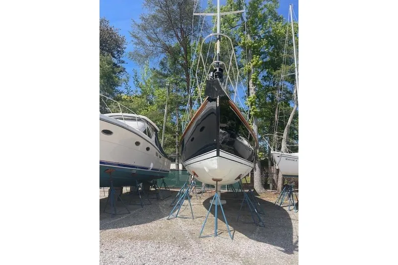 Slide: The Image of 1993 Sabre 38 sailboat on stands, surrounded by trees and other boats. - 27
