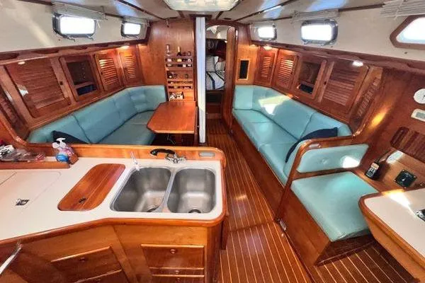 Slide: The Image of Interior of a 1993 Sabre 38 sailboat with wood finish and teal seating. - 3