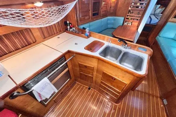 Slide: The Image of 1993 Sabre 38 yacht interior with wooden cabinetry, dual sink, and cozy seating area. - 4