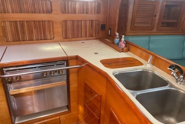 Slide: The Image of 1993 Sabre 38 yacht interior galley with wood finish, dual sink, and stove. - 5