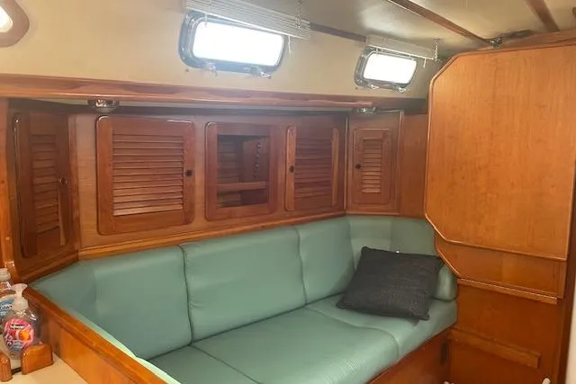 Slide: The Image of Interior of 1993 Sabre 38 sailboat with teal seating and wooden cabinetry. - 7