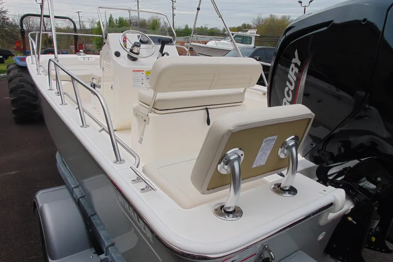 Slide: The Image of 2026 Boston Whaler 170 Montauk boat interior with Mercury engine, featuring seating and steering console. - 6