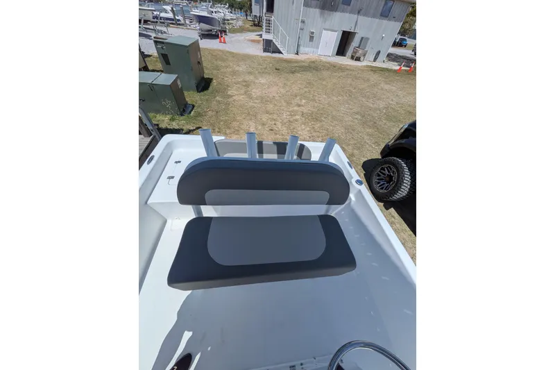 Slide: The Image of 2026 Clearwater 21 Bay boat interior with seating and rod holders, parked outdoors. - 11