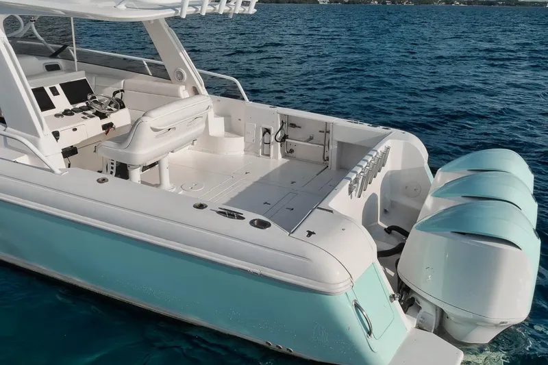 Slide: The Image of 2018 Intrepid 390 Sport Yacht on clear blue water, showcasing triple outboard engines. - 55