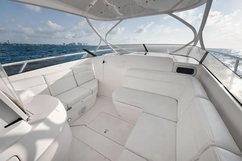 Slide: The Image of 2018 Intrepid 390 Sport Yacht interior with white seating, ocean view, and city skyline. - 26