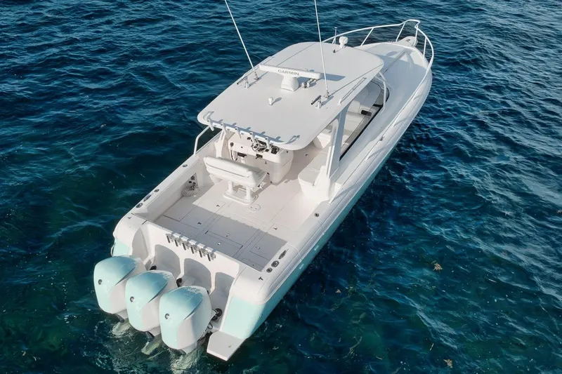 Slide: The Image of 2018 Intrepid 390 Sport Yacht on clear blue water, showcasing triple outboard engines. - 58