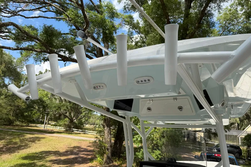 Slide: The Image of 2023 Sea Fox 288 Commander boat with rod holders and canopy, set against a lush, green backdrop. - 17