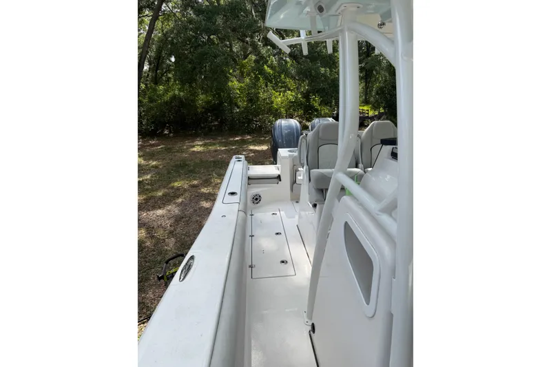 Slide: The Image of 2023 Sea Fox 288 Commander boat interior with seating and console, surrounded by trees. - 20