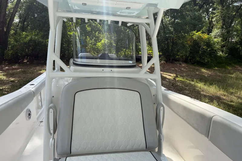 Slide: The Image of 2023 Sea Fox 288 Commander boat interior with seating and console, surrounded by lush greenery. - 25