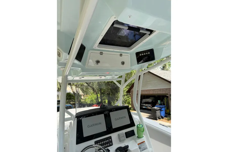 Slide: The Image of 2023 Sea Fox 288 Commander boat dashboard with Garmin displays and overhead storage. - 4