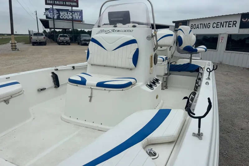 Slide: The Image of 2007 Bay Stealth 2230 boat with blue and white seating at a boating center. - 10