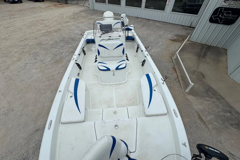 Slide: The Image of 2007 Bay Stealth 2230 boat with blue and white seating, parked outside a building. - 7