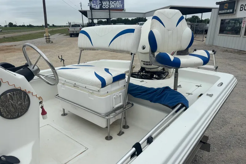 Slide: The Image of 2007 Bay Stealth 2230 boat interior with white and blue seating, steering wheel, and Evinrude motor. - 9