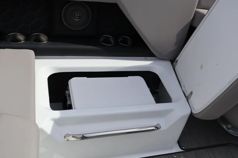 Slide: The Image of 2026 Four Winns H4 boat interior storage compartment with open lid and integrated speaker. - 17