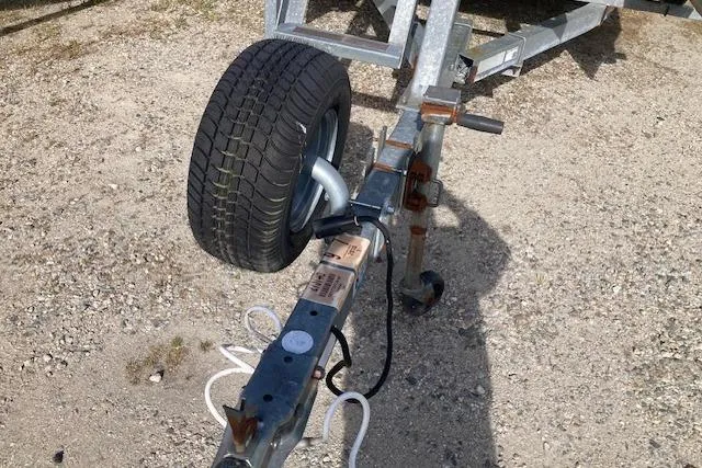 Slide: The Image of Trailer hitch and wheel of a 2010 Sweetwater Tuscany 2086 on gravel surface. - 13
