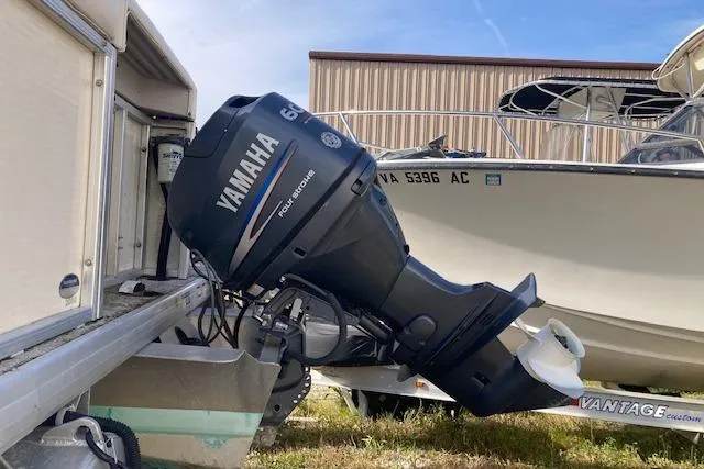 Slide: The Image of Yamaha 60HP outboard motor on 2010 Sweetwater Tuscany 2086 boat, parked outdoors. - 4