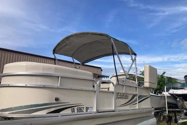Slide: The Image of 2010 Sweetwater Tuscany 2086 pontoon boat with canopy, parked outdoors under blue sky. - 11
