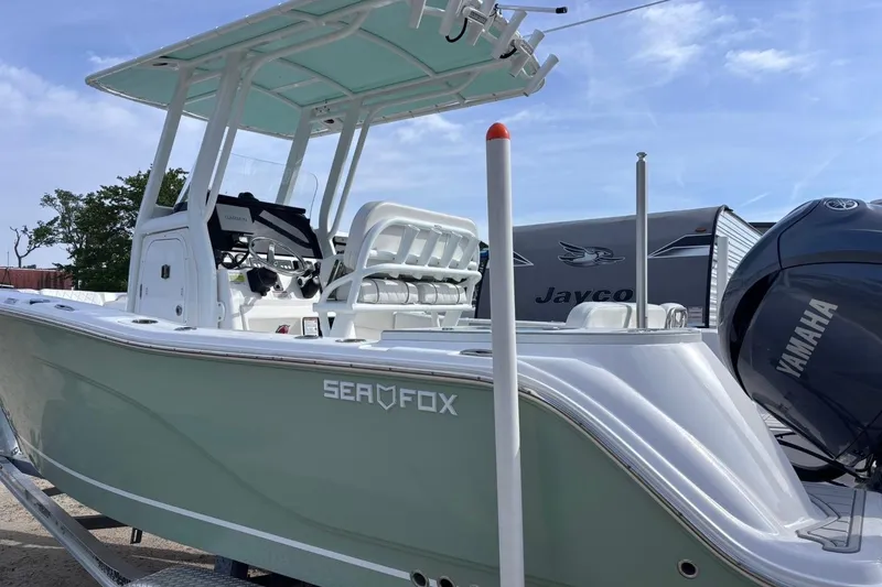 Slide: The Image of 2025 Sea Fox 228 Commander boat with Yamaha engine, parked outdoors. - 2