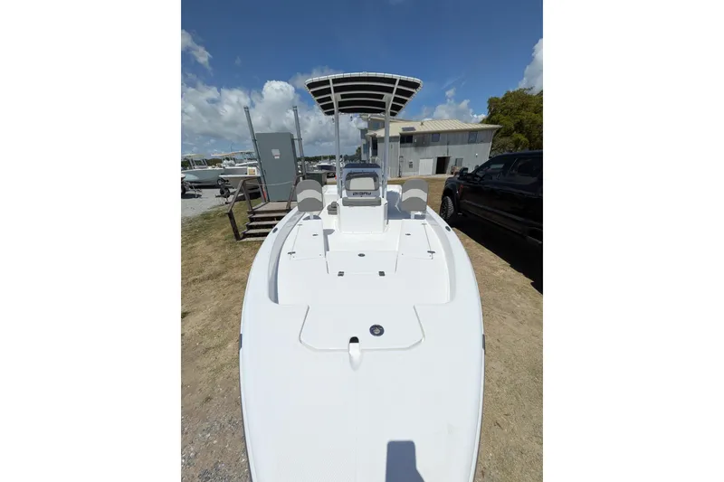 Slide: The Image of 2026 Clearwater 21 Bay boat with T-top, parked outdoors under a clear sky. - 4