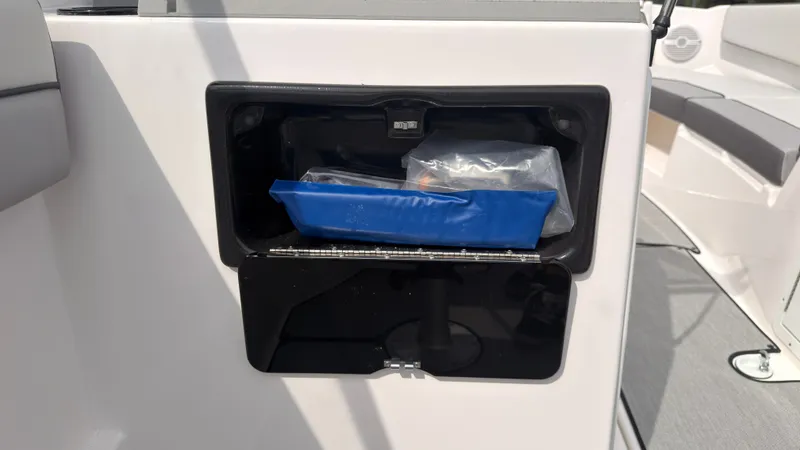 Slide: The Image of A storage compartment on a Yamaha AR220 boat with a blue bag and other items. - 24