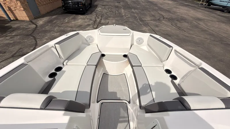 Slide: The Image of The image shows the bow area of a Yamaha AR220 boat with white cushioned seats and cup holders. - 34