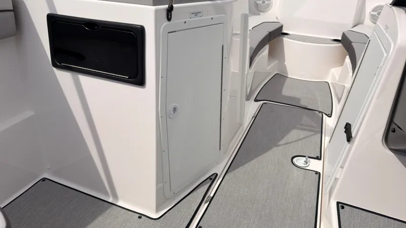 Slide: The Image of The image shows the interior of a Yamaha AR220 boat with gray carpeting and white walls. - 26