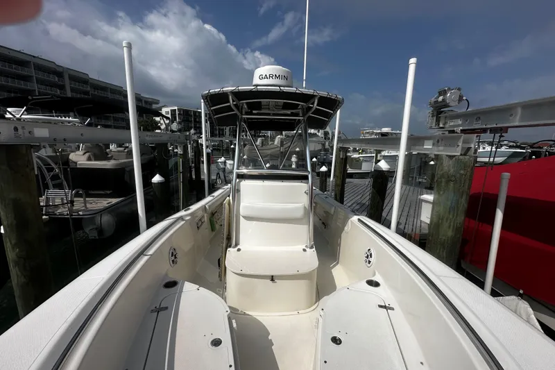 Slide: The Image of 2006 Pursuit 2570 Center Console boat docked at marina under cloudy sky. - 11