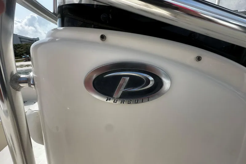 Slide: The Image of Close-up of 2006 Pursuit 2570 Center Console boat logo on white surface. - 12