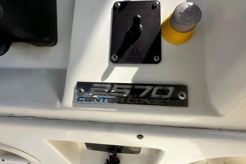Slide: The Image of 2006 Pursuit 2570 Center Console boat dashboard with control panel and branding. - 13