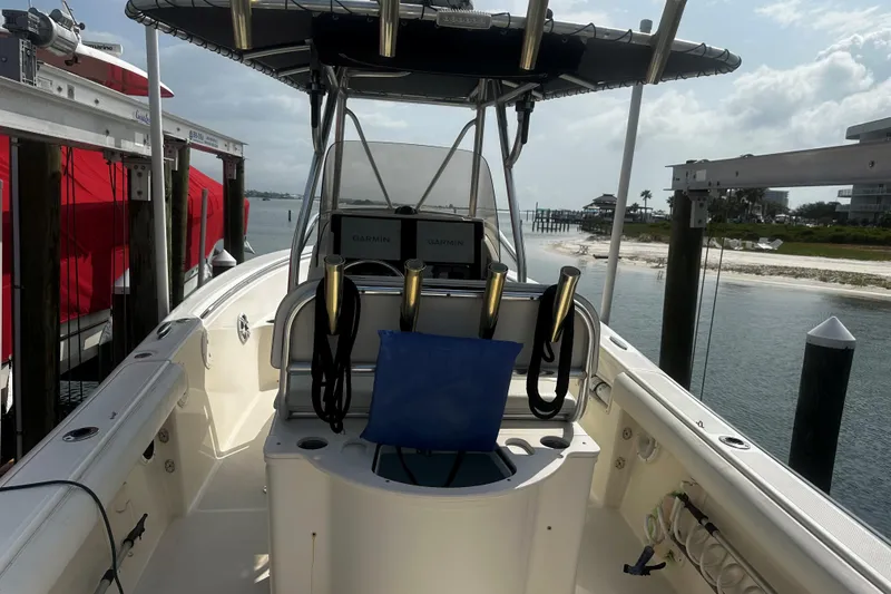 Slide: The Image of 2006 Pursuit 2570 Center Console boat docked near a scenic waterfront. - 4