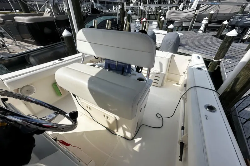 Slide: The Image of 2006 Pursuit 2570 Center Console boat interior at dock, featuring helm and seating area. - 5