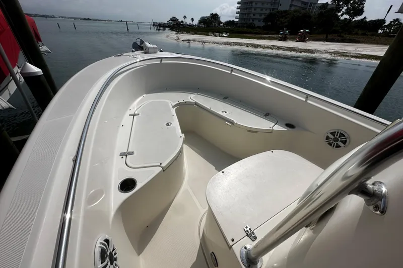 Slide: The Image of 2006 Pursuit 2570 Center Console boat interior with seating, docked near a scenic shoreline. - 9