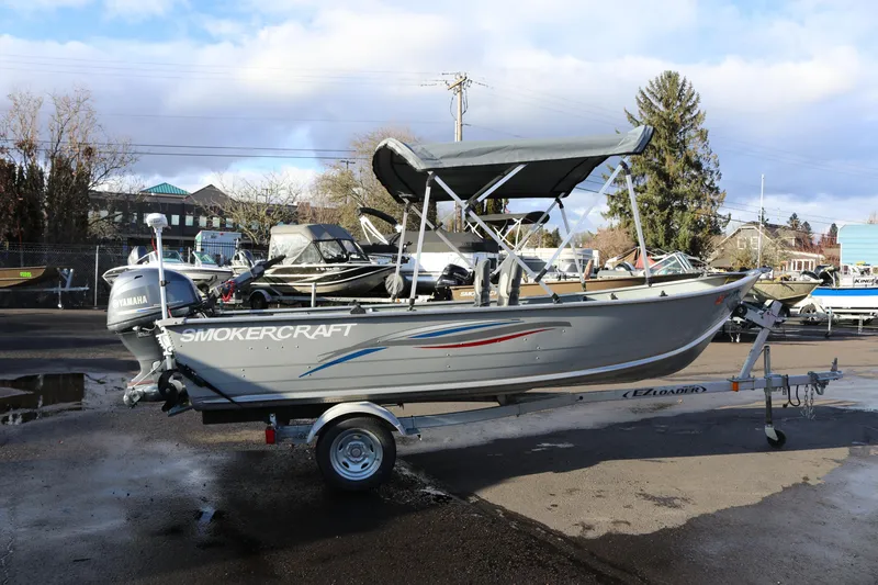 Slide: The Image of 2016 Smoker Craft Alaskan 15 boat on trailer with Yamaha motor, parked outdoors. - 10