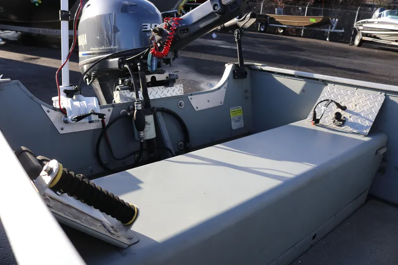 Slide: The Image of 2016 Smoker Craft Alaskan 15 boat interior with Yamaha motor, showcasing seating and controls. - 7