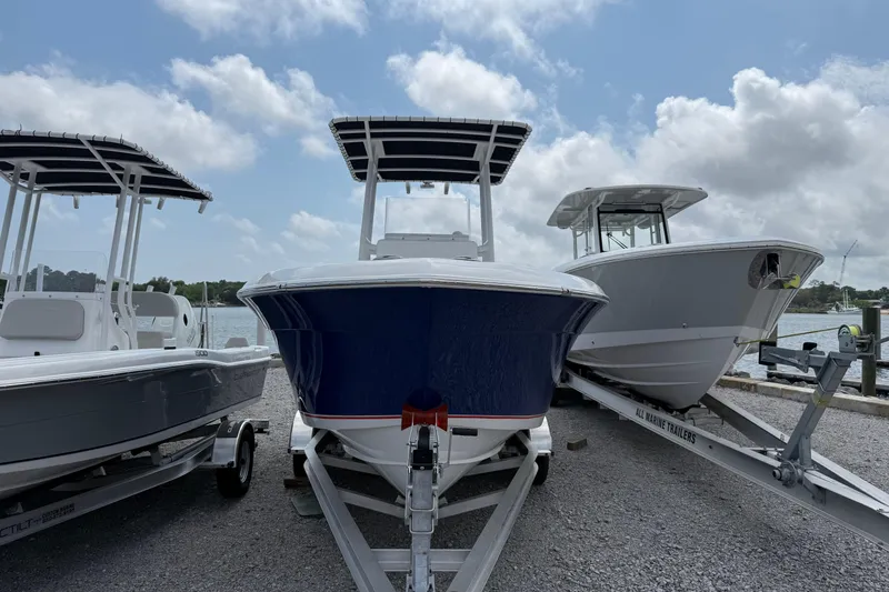 Slide: The Image of 2026 Clearwater 2200 Center Console boat on trailer, dockside view. - 3