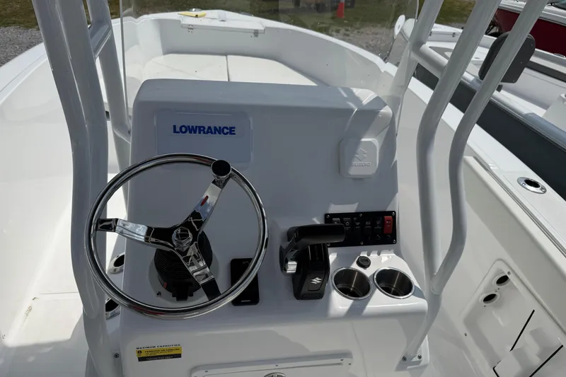 Slide: The Image of Clearwater 2200 Center Console 2026 boat dashboard with steering wheel and controls. - 6