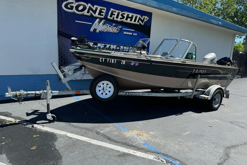 The Image of 2000 Lund 1600 Pro Sport boat on trailer outside Gone Fishin' Marine store. - 1
