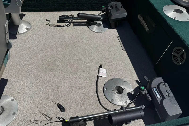 Slide: The Image of Interior of a 2000 Lund 1600 Pro Sport boat, featuring fishing equipment and seating. - 11