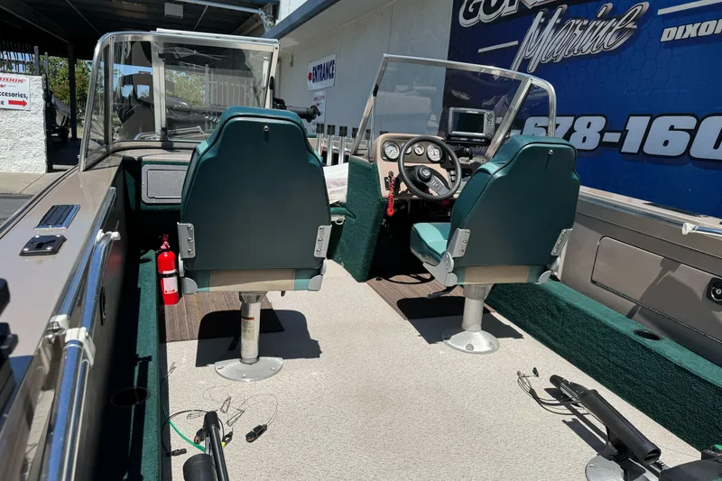 Slide: The Image of Interior of a 2000 Lund 1600 Pro Sport boat with green seats and steering console. - 13