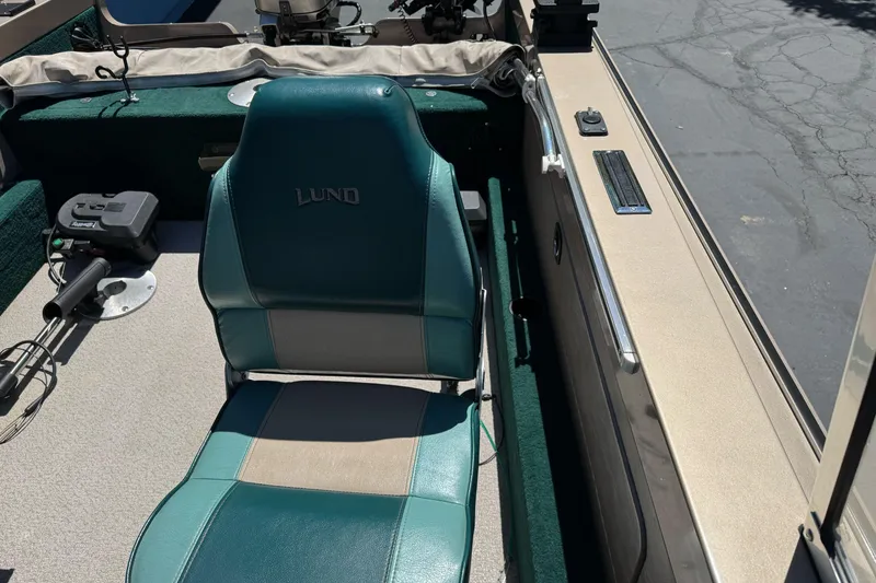Slide: The Image of 2000 Lund 1600 Pro Sport boat interior with teal seating and fishing equipment. - 14